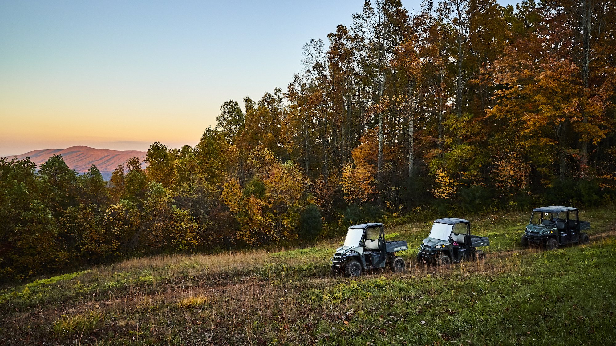 Off-road vehicles on a ridge at Primland at sunset
